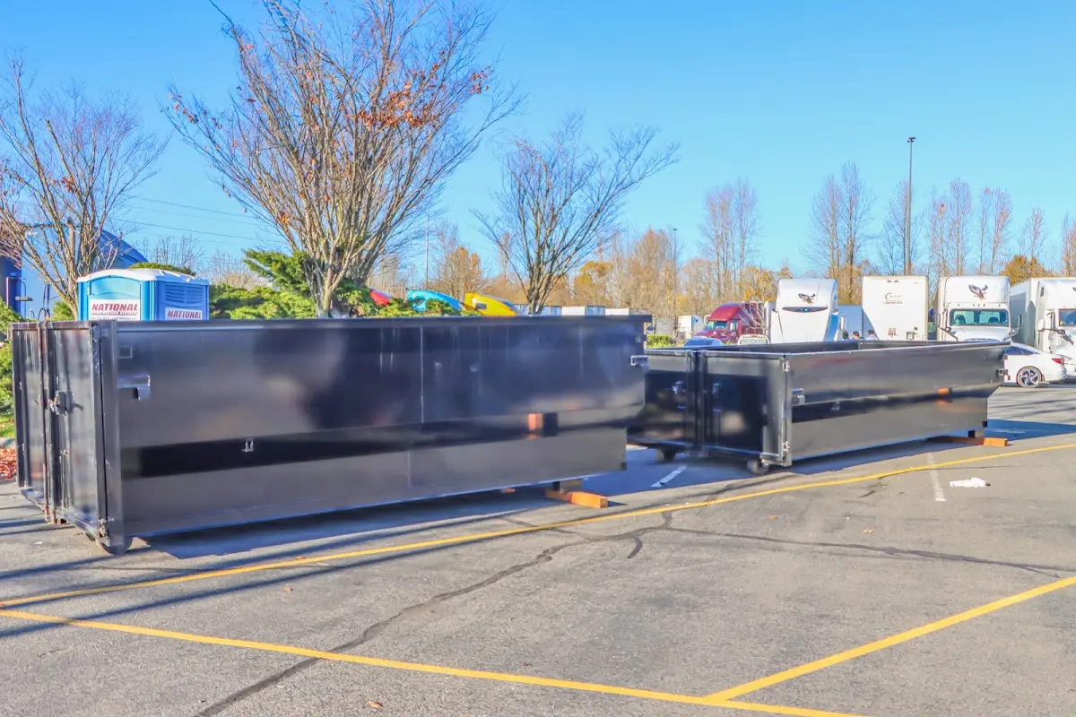 Professional dumpster rental service with roll-off container on residential driveway in Manhattan